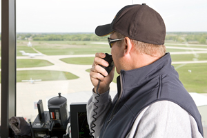 air traffic controller in an airport control tower, directing an airplane on a runway